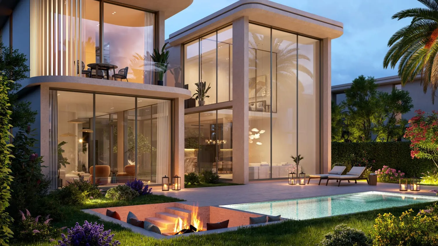 A villa at dusk from its pool terrace: double-height glazing lit from inside, a lawn, sun loungers, a fire pit and the pool