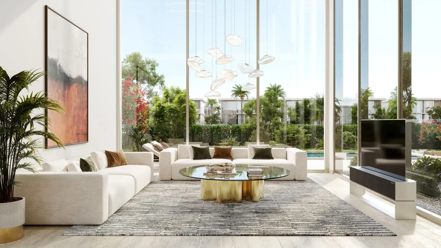 A living room with cream sofas around a gold coffee table, tall glazing on two sides and a garden with a pool beyond